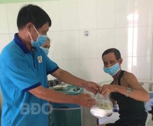 Thành viên Chi hội Mái Ấm Việt trao suất ăn cho bệnh nhân tại TTYT huyện Vân Canh.